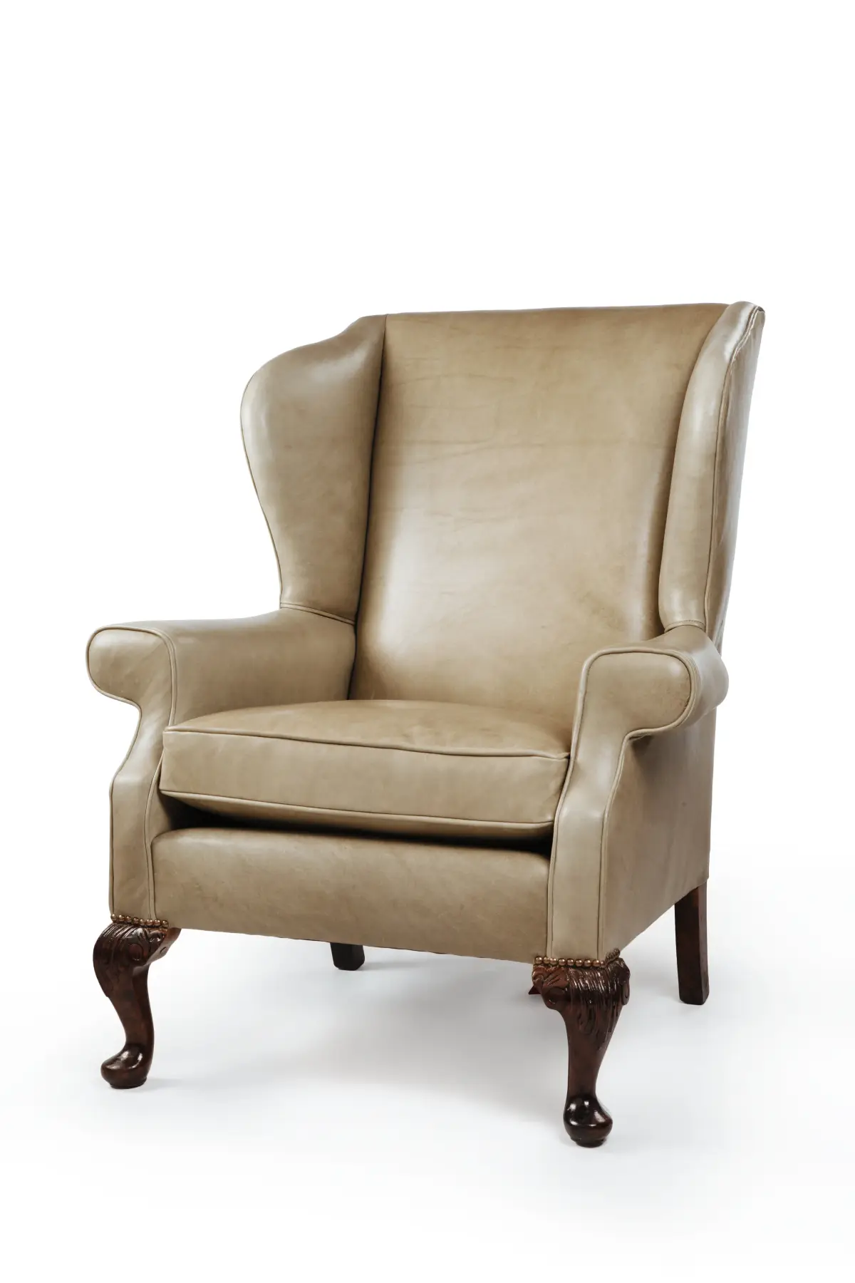 Taupe leather wing armchair with carved cabriole legs, studio product photography